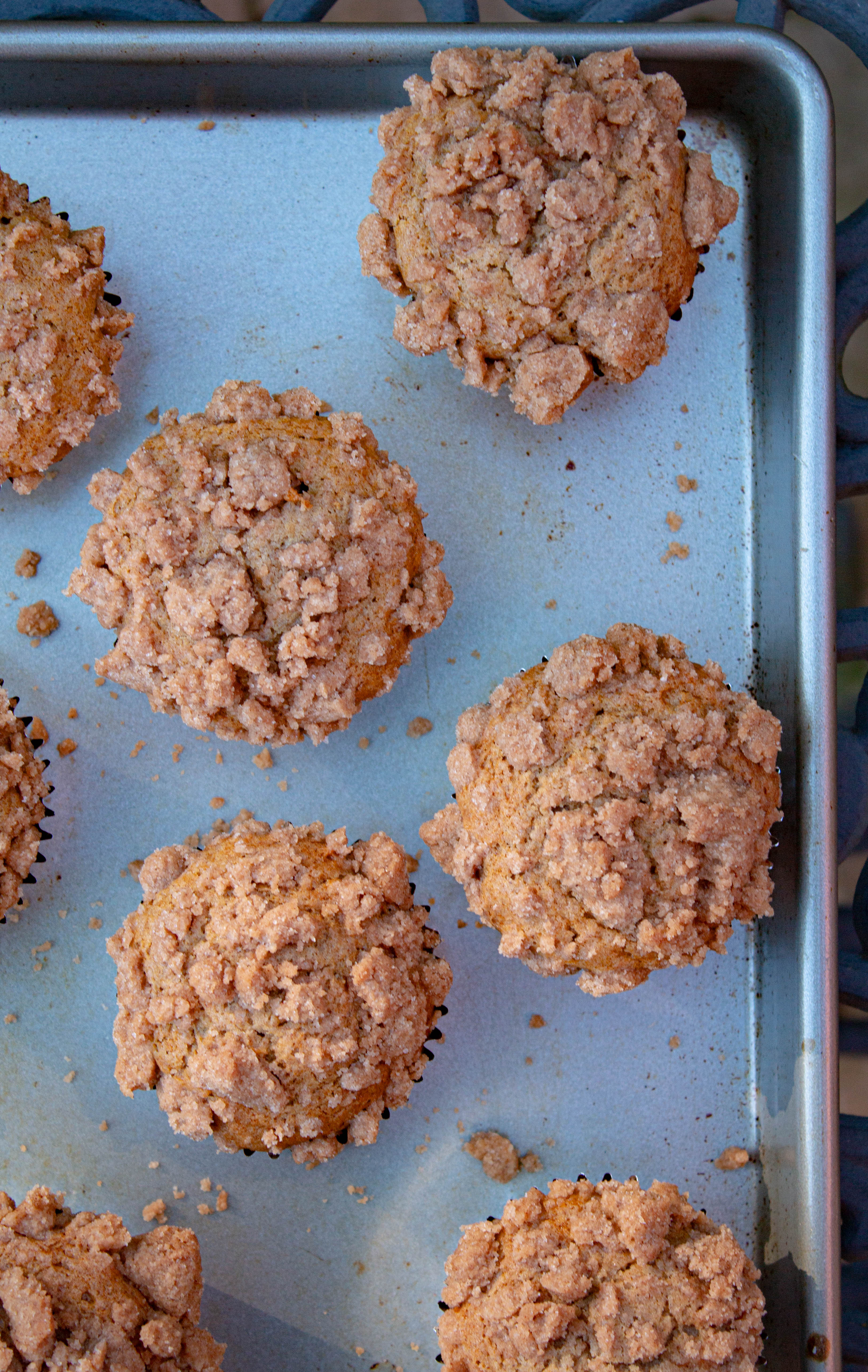 Muffins on a sheet pan with streusel crumbs.