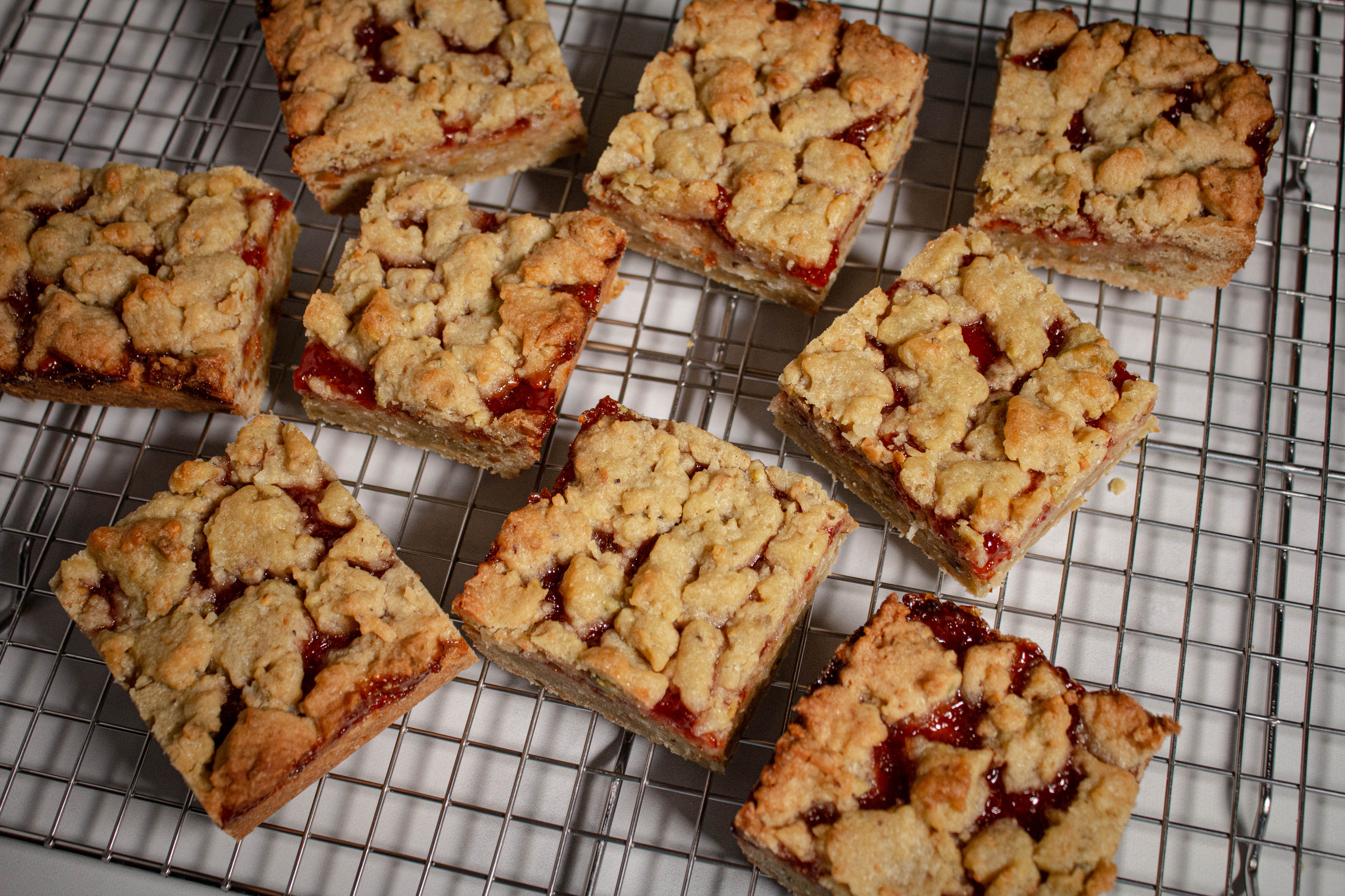 Sour cherry jam bars scattered on a wire rack.